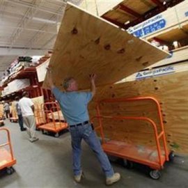 A man loads plywood to board up windows at a Home Depot store in Freeport on Long Island