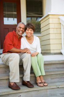 Couple on their front steps who just used a fixed rate mortgage to buy a home.