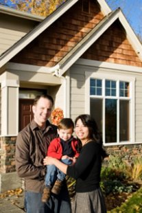 Family posing in front of their home.