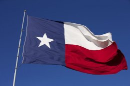 Texas flag on flag pole waving in the eastward bound wind